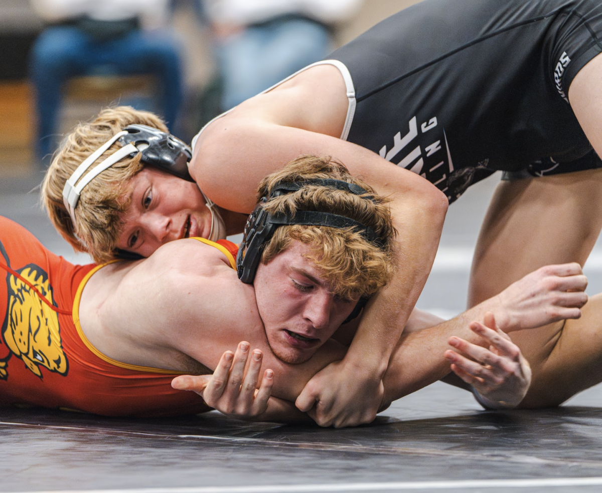 Holding his opponent against the mat, senior Grayson Hagen competes in the boys varsity wrestling dual against Lawrence High on Jan. 22.